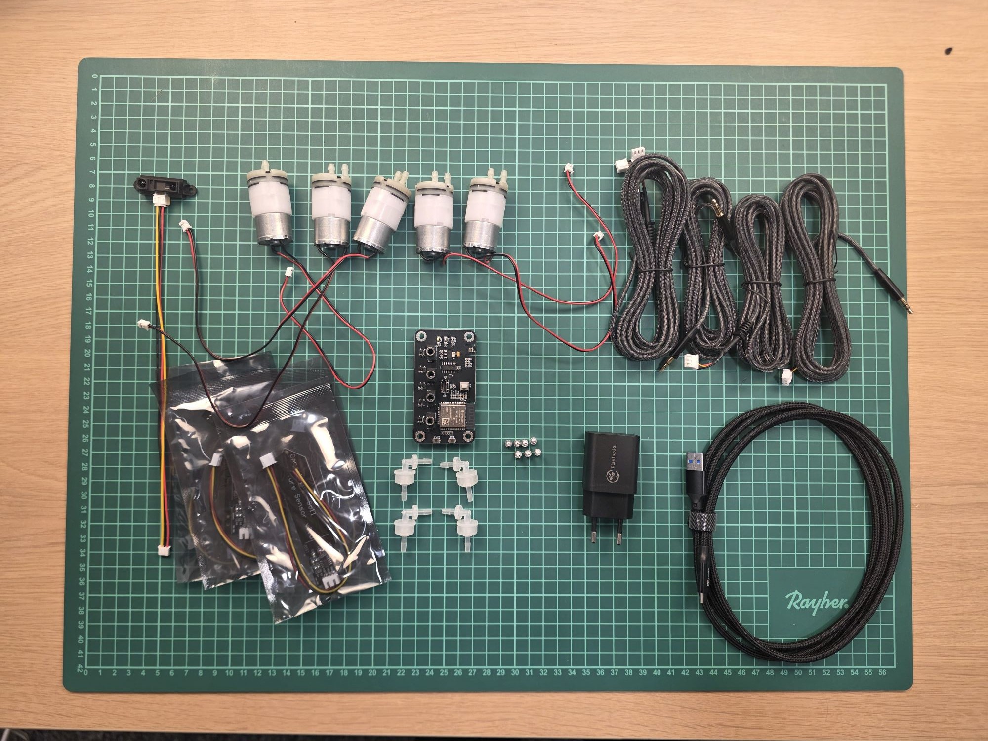 Everything in the DIY kit laid out: PCB, 5 pumps, 4 soil sensors, IR sensor, cables and power supply